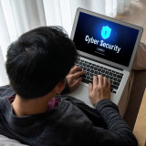 Man kijkt op laptop met cybersecurity