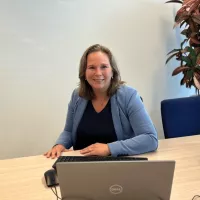 Anouk van den Dungen achter laptop op kantoor Raamsdonksveer