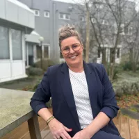 Sandra de Leeuw op een bankje in de tuin van kantoor Wageningen
