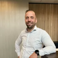 Max Platvoet lachend in de gang op kantoor Tilburg
