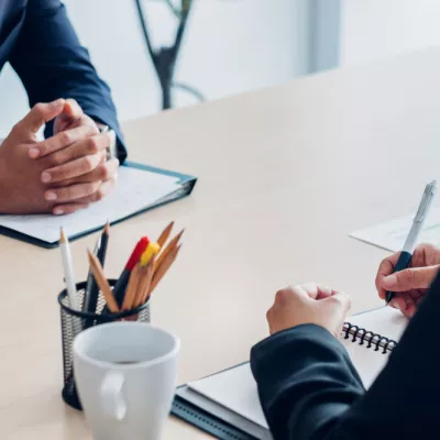 Twee mensen aan tafel in gesprek over het oprichten van een ondernemingsraad