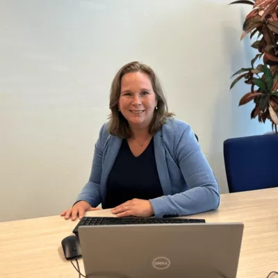 Anouk van den Dungen achter laptop op kantoor Raamsdonksveer