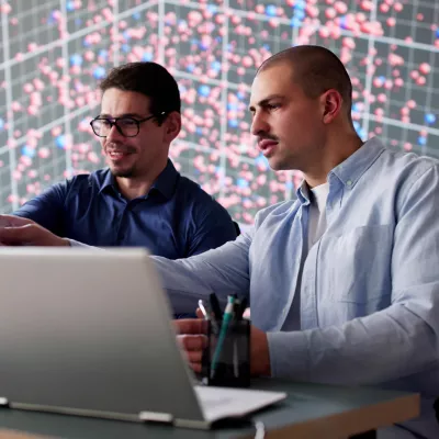 Twee mensen achter computer bezig met cyber security