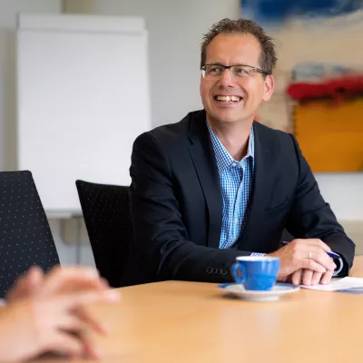 man aan tafel met contract voor zich