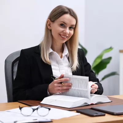 Vrouw met boek achter bureau
