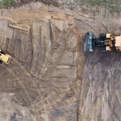 Luchtfoto van een ontwikkelterrein met bouwmachines