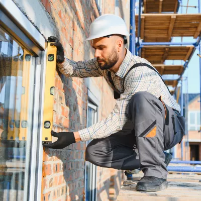 Bouwvakker die raaminstallatie controleert