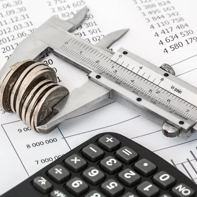 Caliper measuring coins on financial charts