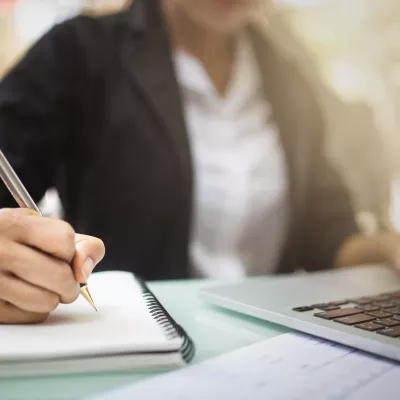 Persoon maakt aantekeningen in notitieblok