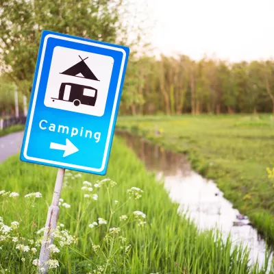 Verkeersbord met camping en sloot
