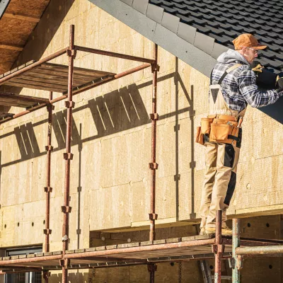 werknemer legt dakbedekking op huis