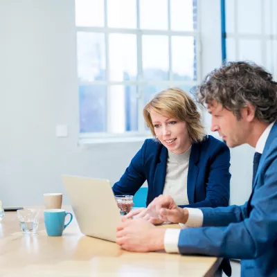 man-en-vrouw-in-gesprek-bij-laptop_accountancy