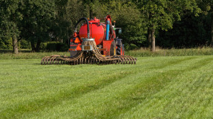 Tractor rijdt drijfmest op grasland