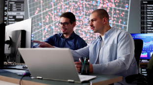 Twee mensen achter computer bezig met cyber security
