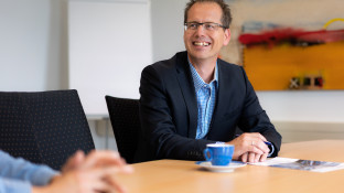 man aan tafel met contract voor zich