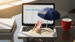 Laptop op strand met parasol