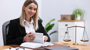 Vrouw met boek achter bureau