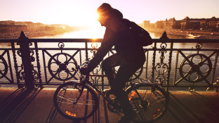 Man op een fiets fietst over een brug