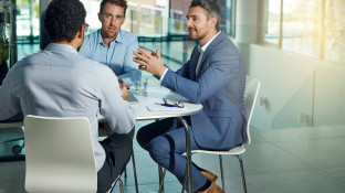 Mannen bespreken vergoedingen aan arbeidsmigranten