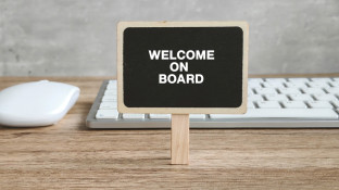 Bordje op bureau met welkom on board