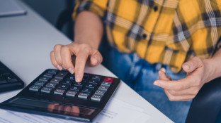Werkgever met rekenmachine om belastingen te berekenen