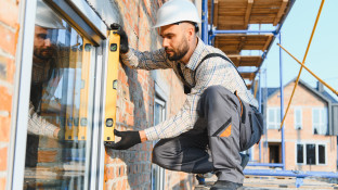Bouwvakker die raaminstallatie controleert