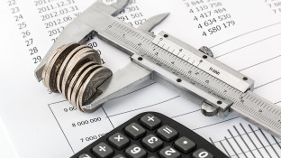 Caliper measuring coins on financial charts