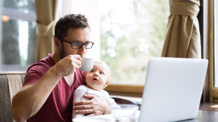 Man met kind op schoot achter laptop