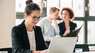 Vrouw typend achter laptop