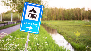 Verkeersbord met camping en sloot